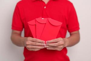 man holding Chinese red envelope, money gift for happy Lunar New Year holiday photo