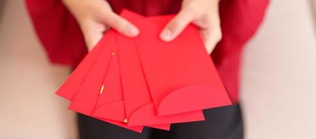 mujer con sobre rojo chino, regalo de dinero para felices vacaciones de año nuevo lunar foto