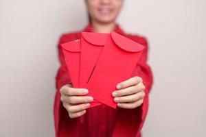 Woman holding Chinese red envelope, money gift for happy Lunar New Year holiday photo