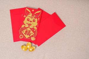 Chinese red envelope with gold bullion, money gift for happy Lunar New Year holiday. Chinese sentence means happiness, healthy, Lucky and Wealthy photo