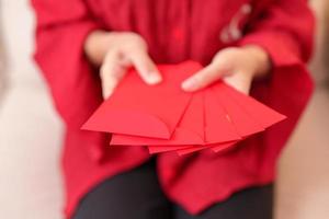 Woman holding Chinese red envelope, money gift for happy Lunar New Year holiday photo