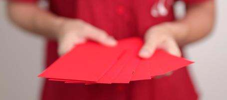 Woman holding Chinese red envelope, money gift for happy Lunar New Year holiday photo