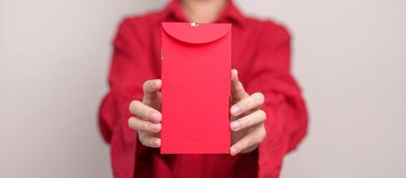 mujer con sobre rojo chino, regalo de dinero para felices vacaciones de año nuevo lunar foto