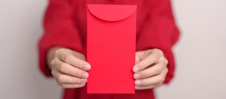 mujer con sobre rojo chino, regalo de dinero para felices vacaciones de año nuevo lunar foto