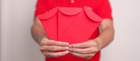 man holding Chinese red envelope, money gift for happy Lunar New Year holiday photo