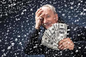 man with a bundle of dollars in snowfall photo