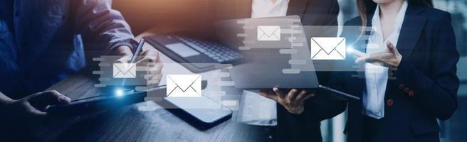 Businessman hands using Laptop typing on keyboard and surfing the internet on office table with email icon, email marketing concept, send e-mail or news letter, online working internet network. photo