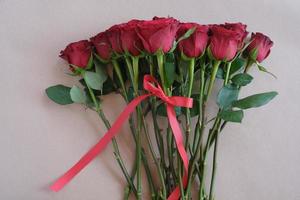 Bunch of rosy roses isolated on brown background. Valentine's day, wedding, birthday and special occasion concept. Flat lay, top view. photo