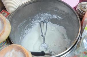 Buckets of coconut milk ice cream at local market stall photo