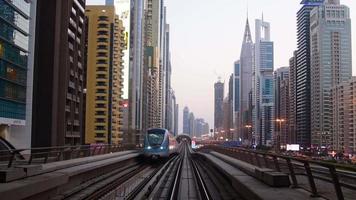 Dubai, UAE ,2022 - metro arrives to metro stop in city of Dubai with scenic modern buildings panorama background video