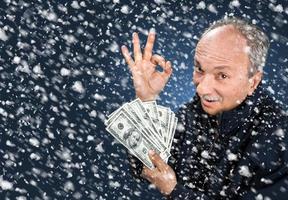 man with a bundle of dollars in snowfall photo