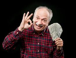 elderly man showing fan of money photo