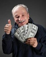 Happy elderly man showing fan of money