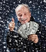 man with a bundle of dollars in snowfall photo