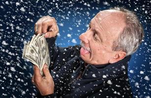 man with a bundle of dollars in snowfall photo