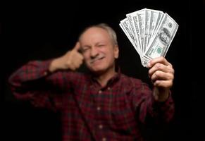 elderly man showing fan of money photo