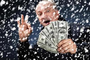 man with a bundle of dollars in snowfall photo