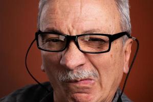 Close-up portrait of an elderly man with skeptical expression photo