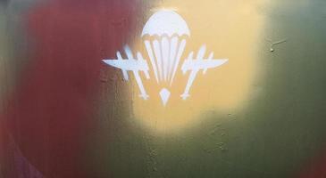 The symbol or badge of the Airborne Troops of the Ukrainian Army painted with white paint on metal. Background of the air assault group, division. Airborne. Ukraine, Kyiv - October 9, 2022. photo