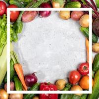 Frame by vegetables and creative white square frame on them on concrete background with copy space. photo