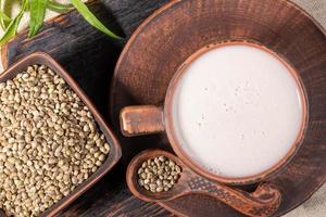 Top view hemp milk and grains in brown ceramic crockery. photo