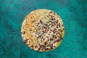Beans laid out on emerald green background in circle with imitation Globe. photo