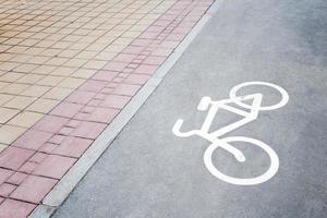 Part of paved sidewalk and bike paths with the image of bicycle. photo