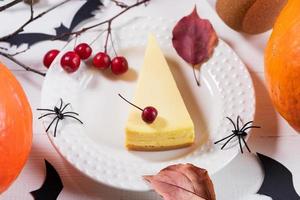 diseño de mesa de fiesta de halloween con pastel de calabaza, calabazas, arañas negras, búhos, ramitas secas. foto