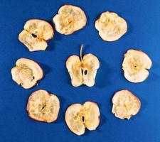 chips de manzana dispuestos en círculo sobre fondo azul brillante. foto