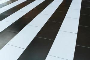 Close-up abstract diagonal pattern of alternating black and white stripes on the floor. photo