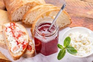 desayuno casero saludable con pan, mermelada de fresa dulce y cuajada. foto