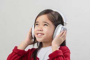 Lttle girl Asia cute enjoying her music headphones photo