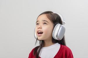 Lttle girl Asia cute enjoying her music headphones photo