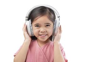 A little beautiful girl asia putting the headphone isolated on a white background. photo