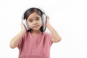 A little beautiful girl asia putting the headphone isolated on a white background. photo