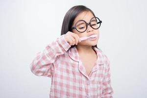 little girl Asia brushing teeth happily white background photo