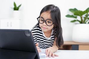 Asian child girl student wow excited on video call learning to studying online class or person learn from home school with tablet photo