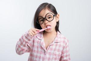 niña asia cepillarse los dientes felizmente fondo blanco foto