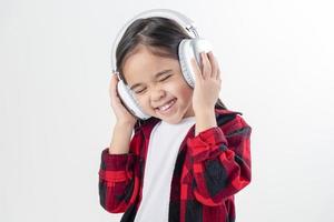 pequeña niña asia linda disfrutando de sus auriculares de música foto