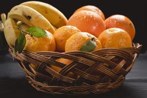 A platter of fresh winter fruits, banana, orange and mandarin photo