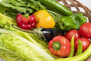 una cesta de verduras frescas para una vida sana y la dieta keto, tomates, pepinos, pimientos verdes, berenjenas, lechugas y berros foto