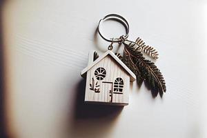 Real estate concept - Key ring and keys on white wooden background photo