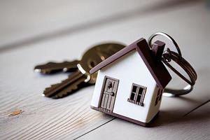 Real estate concept - Key ring and keys on white wooden background photo