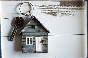 Real estate concept - Key ring and keys on white wooden background photo