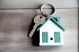 Real estate concept - Key ring and keys on white wooden background photo