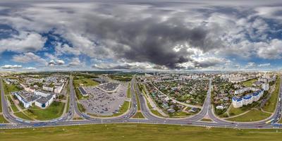 aerial full seamless spherical hdri 360 panorama view above road junction with traffic in small provincial town with private sector and high-rise apartment buildings in equirectangular projection. photo