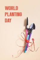 World Planting Day text with shovels and rakes for gardening. flat lay. Vertical format