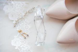 beautiful wedding accessories. Bride shoes, perfumes on a white veil photo