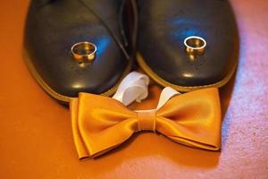 Set of groom clothes. Wedding rings, shoes, cufflinks and bow tie photo