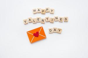 carta de amor, corazón rojo, letras de madera feliz día de san valentín. concepto de celebración del día de san valentín. foto